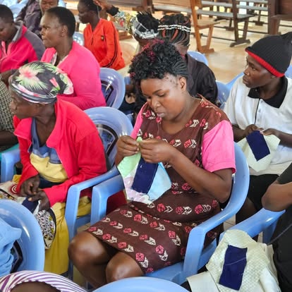 A woman stitching a reusable pad by hand